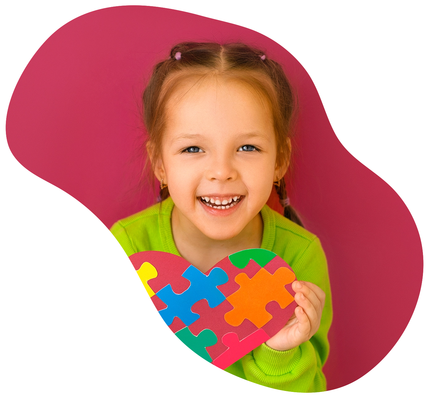 A cheerful happy girl shows a heart from a puzzle